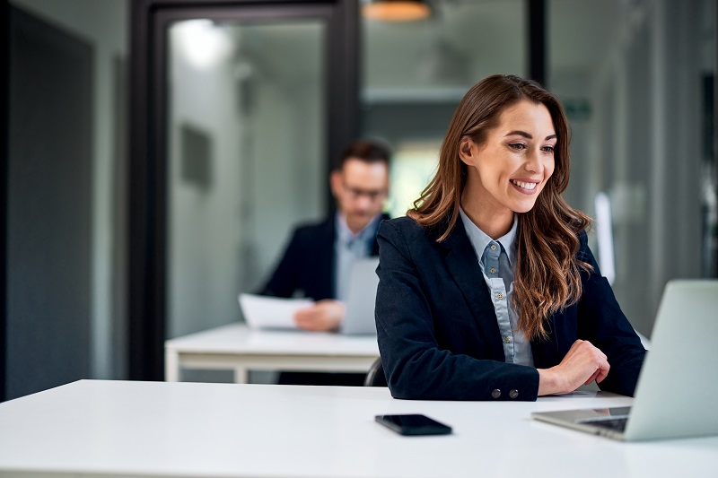 A happy pretty businesswoman having an online meeting with clients over a laptop, elegantly dressed.
